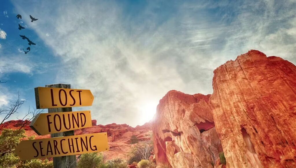 Wegweiser mit den Worten „Lost“, „Found“ und „Searching“ vor Felsenlandschaft – Symbol für Orientierung, innere Suche und die regulierende Kraft der Craniosacraltherapie.